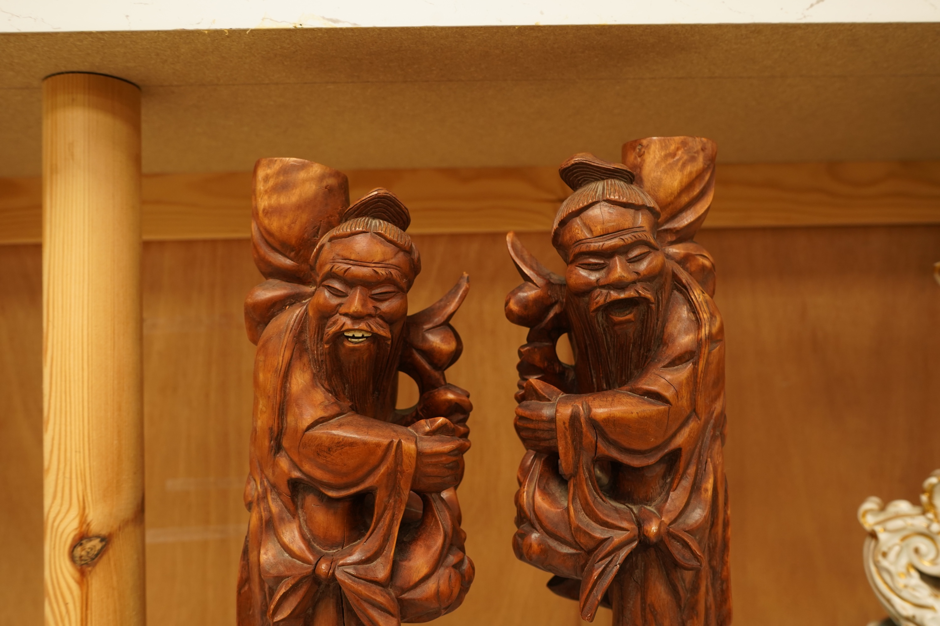 A pair of 20th century Chinese carved wood figures of sages, 31cm